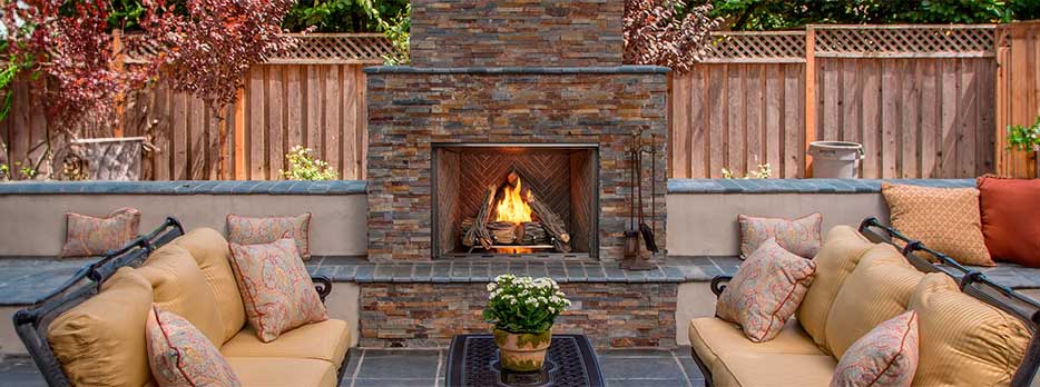 Courtyard Outdoor Gas Fireplace by Outdoor Lfiestyles lifestyle image in a backaard with a brick facade for the fireplace